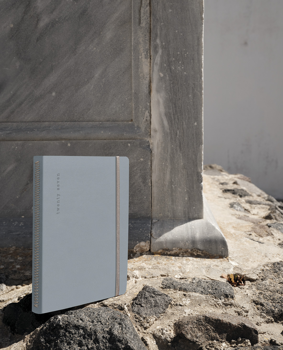 a blue Desires diary standing on the feet of a marble column