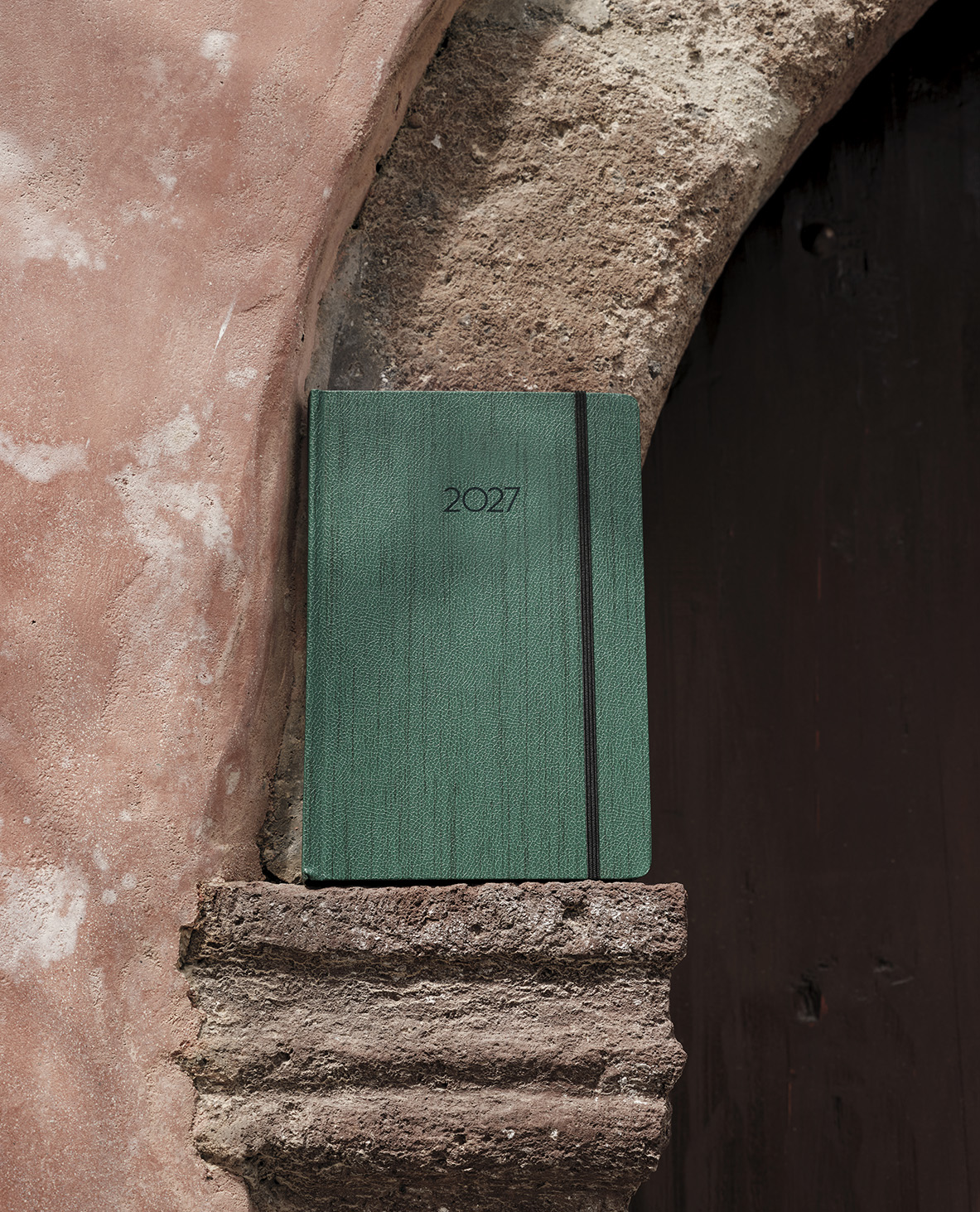 Landscape green diary standing in a rustic doorway